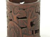 a wooden cup with carvings on it on a white surface
