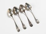 four spoons are lined up in a row on a white surface