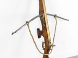 an image of a wooden gun with a rope hanging from it ' s side