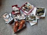 plusieurs paires de chaussures dans une boîte posée sur le sol