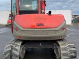 an image of a red and gray tractor parked in a parking lot