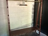 a coat rack with a coat hanger on it in the corner of a room