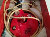 a red box that has a hose and a red canister in it