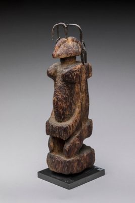 l'image d'une statue en bois représentant un homme coiffé d'un chapeau