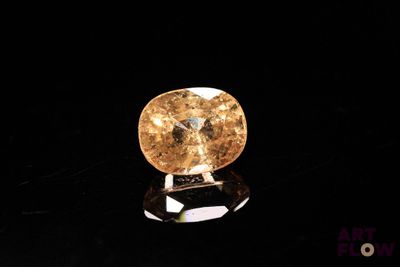 un diamant jaune sur une surface noire, avec un fond noir