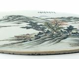 a plate with a painting on it on a white surface
