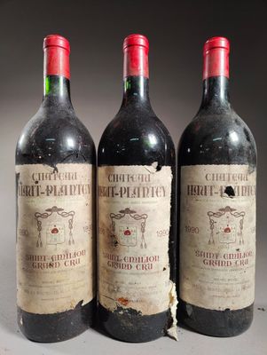 trois bouteilles de vin rouge posées côte à côte sur une table