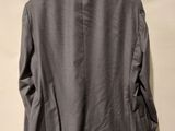 the back of a gray jacket hanging on a hanger