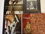 Plusieurs livres sont posés sur une table, avec une horloge devant eux.