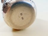a silver object on a white surface with a white background
