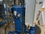 a blue water heater in a room with pipes and pipes