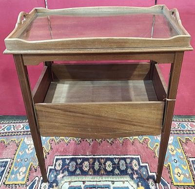 a small wooden table with a glass top on a rug