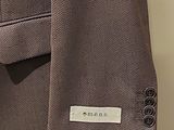 a close up of a suit on a hanger in a room