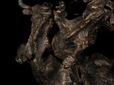 a bronze statue of a man riding a bull