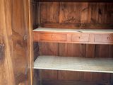 a wooden cabinet with shelves and a drawer inside of it