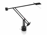une photo d'une lampe de bureau noire posée sur une surface blanche