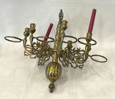 un lustre en laiton orné de bougies rouges