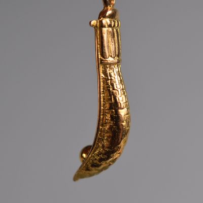 un pendentif plaqué or orné d'une tête d'éléphant