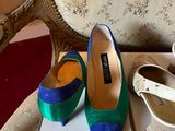 pair of blue and green shoes sitting on top of a box on a chair