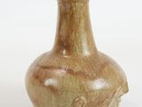 a brown vase that is sitting on a white surface