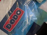 a bag of t - shirts on a bed with a remote control