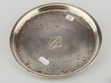 a silver plate with a bird on it sitting on top of a table