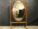 a large mirror sitting on top of a wooden stand next to a black wall