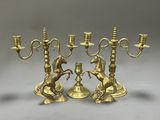 three brass candelabs with horses on them and a horse figurine