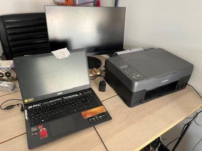 a laptop and printer sitting on a desk next to each other