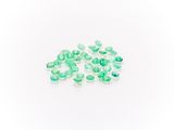 a pile of green glass beads sitting on top of a white surface