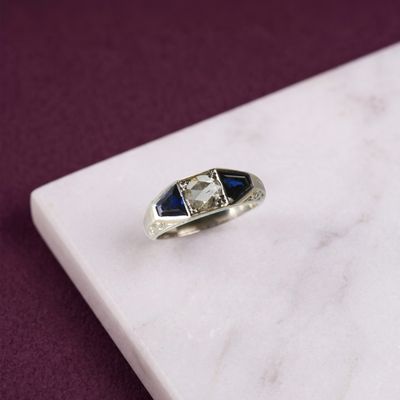 l'image d'une bague contenant une pierre bleue