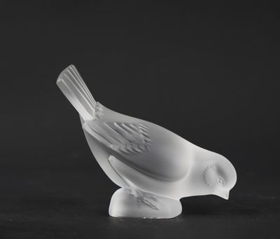 black and white photograph of a glass bird on a black surface