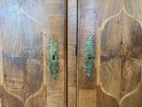 a wooden cabinet with two doors and a green handle