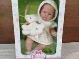 a doll in a box with a teddy bear in it