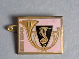 a close up of a gold and pink badge with a snake on it
