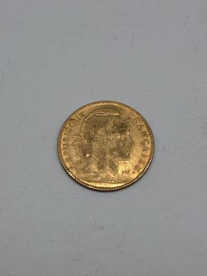 a close up of a gold coin on a white surface