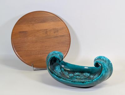 un petit bol bleu posé à côté d'une assiette en bois