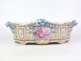 figurine en porcelaine représentant une femme vêtue d'une robe rose à fleurs bleues