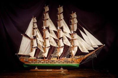 a model of a sailboat on a wooden table