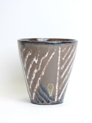 a close up of a cup on a white surface