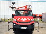 a red truck parked in a parking lot with a crane on top of it
