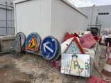 a lot of signs that are sitting on the ground