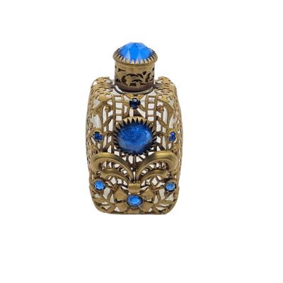 an image of a blue glass perfume bottle sitting on top of a white surface