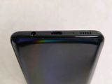 a close up of the back of a black cell phone on a white surface