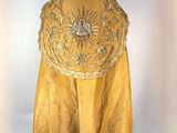 an image of a yellow cape with a gold flower design on it
