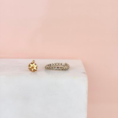 a pair of gold rings sitting on top of a white marble block