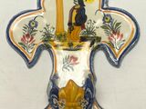 a decorative wall hanging with a cross and a bird on it