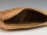 a tan purse with a zipper on it on a white surface