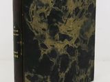 an old book with a black cover and gold foil on it