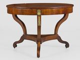 une table ronde avec un plateau en bois et une plaque en laiton sur le plateau